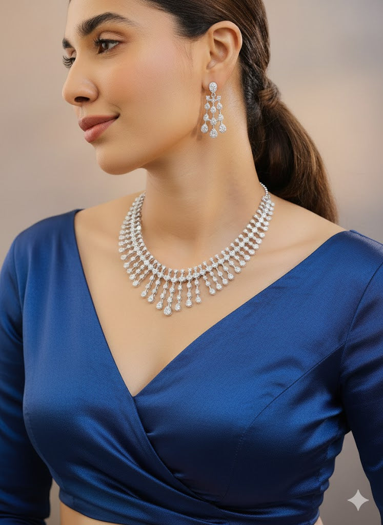 Woman wearing a blue dress and silver jewelry with a blurred background